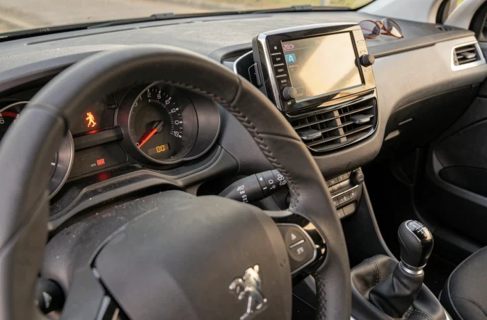 Voyant d'alerte allumé sur le tableau de bord numérique d'une Peugeot 208 intérieur voiture